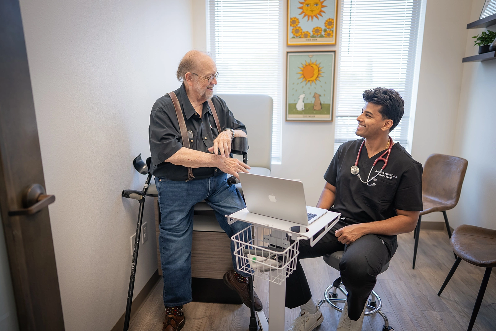 Dr. Rangish Yuvaraj seated at eye level with an older patient during a first appointment.